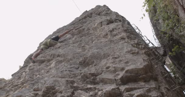ハンサムでフィット感のある男性が頂上に到達することを考えながら上り坂を登っています — ストック動画