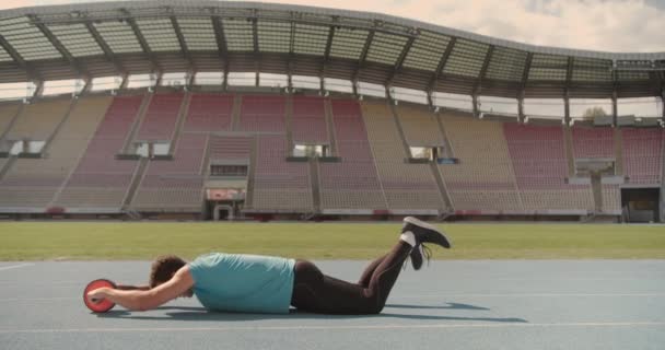 Genç Bir Erkek Stadyumdaki Bir Spor Pistinde Kas Tekerleği Silindiri — Stok video