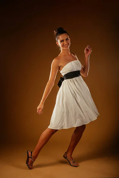 Beyaz Elbiseli Seksi Kız Stüdyoda Açık Kahverengi Arka Planda Poz — Stok fotoğraf