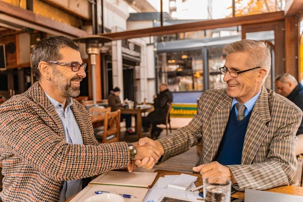 Two Senior Handsome Businessmen Making Deal Smiling While Sitting Cafe — Foto de Stock
