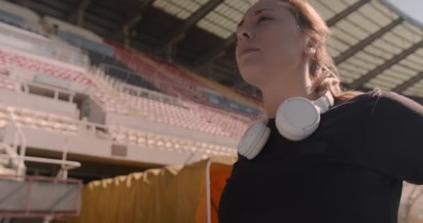 Chica Poniéndose Auriculares Antes Practicar Estadio — Vídeos de Stock