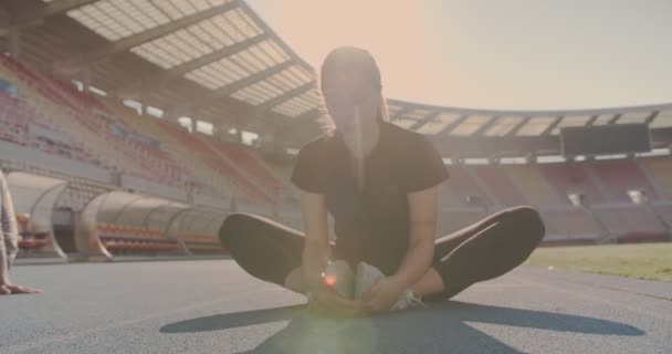 運動の前にスタジアムの中で朝に暖まる一人の女性 — ストック動画
