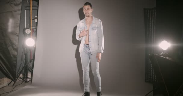 Młody Mężczyzna Modelka Pozowanie Sesji Zdjęciowej Dżinsach Izolowanych Szarości Studio — Wideo stockowe
