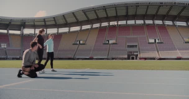 Three Young People Preparing Compete Running Track Empty Stadium — Stock Video
