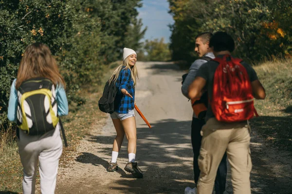 Quatro Amigos Caminhantes Caminhando Enquanto Conversam Estrada — Fotografia de Stock