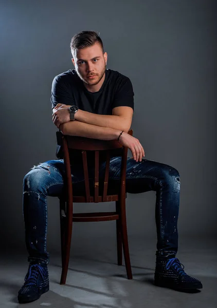Portrait Trendy Handsome Guy Wearing Black Shirt Ripped Jeans Sitting — Stock Photo, Image