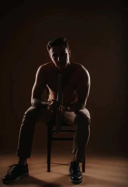 Silhouette of a man sitting on a chair in the studio