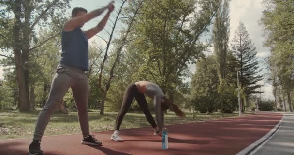 Jeune Couple Tordant Les Hanches Avant Exercice Dans Parc Scène — Video