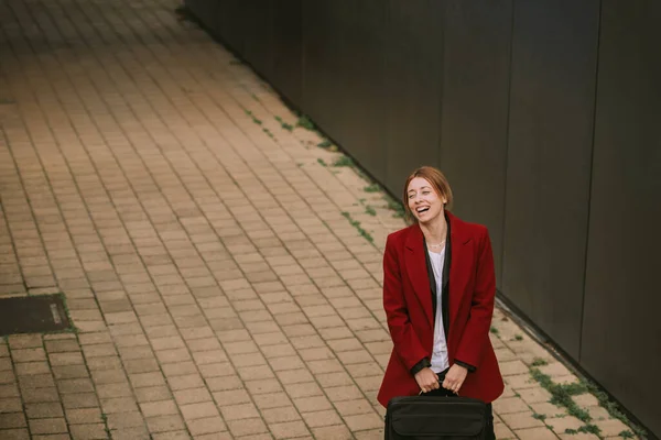 Beautiful blonde business women laughing while standing near the building