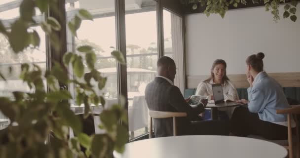 コーヒーショップでミーティングをしている多人種ビジネスの人々 広い角度 コピースペース — ストック動画