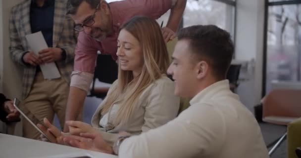 在现代办公场所 不同年龄段的人在一家新成立的公司里一起工作 一边讨论新的想法 一边看平板电脑 近距离拍摄 — 图库视频影像