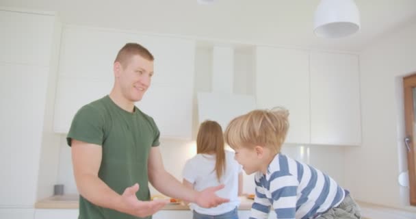Cute Little Kid Playing His Father While Standing Kitchen Counter — Stockvideo