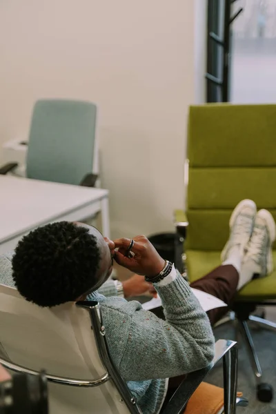 オフィスの椅子の上で寝ている若い疲れきった黒人ビジネスマンのクローズアップ写真 — ストック写真