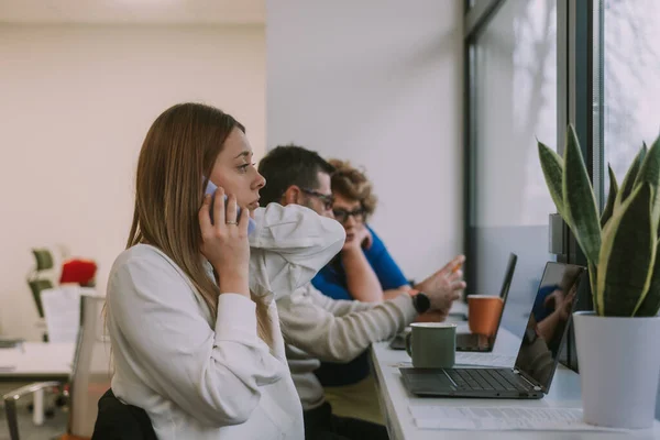 Çekici Sarışın Kadını Dizüstü Bilgisayarı Üzerinde Çalışırken Bir Telefon Aldıktan — Stok fotoğraf