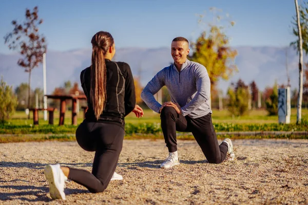 stock image Smiley guy is having a fun conversation and smiling with his girlfriend while they are warming up for their training