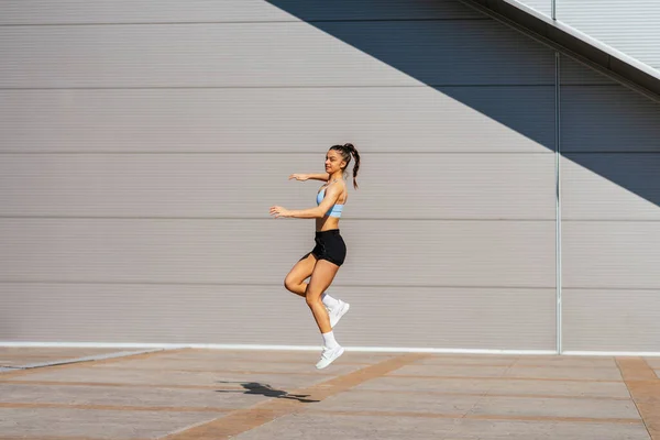 스러운 소녀는 운동하기 뛰어오르고 따뜻하게 하다가 무엇인가 로인해 해졌다 — 스톡 사진