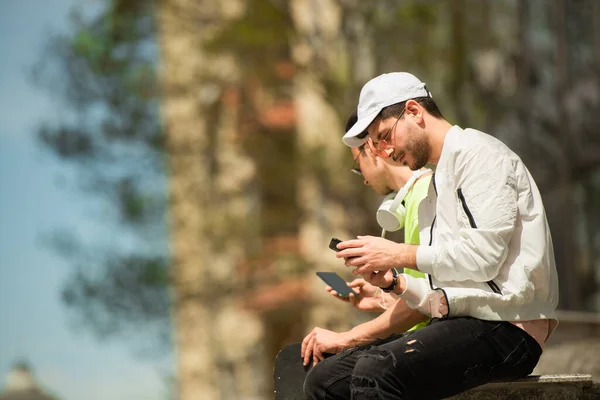 Dos Amigos Están Revisando Teléfono Mientras Están Sentados Uno Cerca —  Fotos de Stock