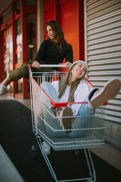 Δύο Όμορφα Κορίτσια Καλάθι Της Αγοράς Διασκεδάζουν Διαφημίσεις Χαμογελώντας Στην — Φωτογραφία Αρχείου