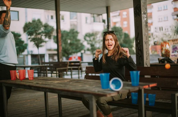 Arkadaşların Ahşap Bankta Otururken Tezahürat Yaparken Bira Pong Oynuyorlar — Stok fotoğraf