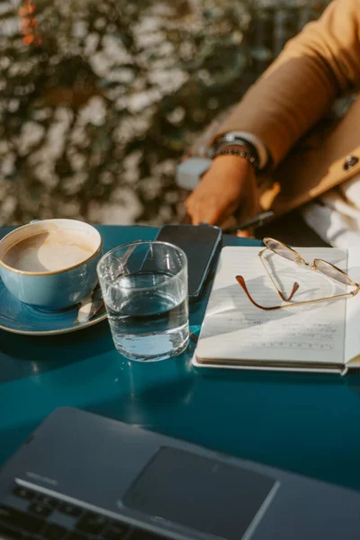 Großaufnahme Des Cafétisches Mit Kaffee Wasser Telefon Notizbuch Und Gläsern — Stockfoto
