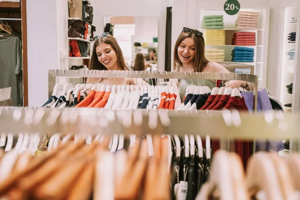 Две Симпатичные Удивительные Девушки Смотрят Груду Одежды Магазине Решают Получить — стоковое фото