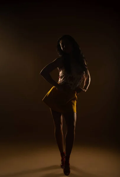 stock image Pretty girl posing with her yellow skirt and floral blouse at the studio