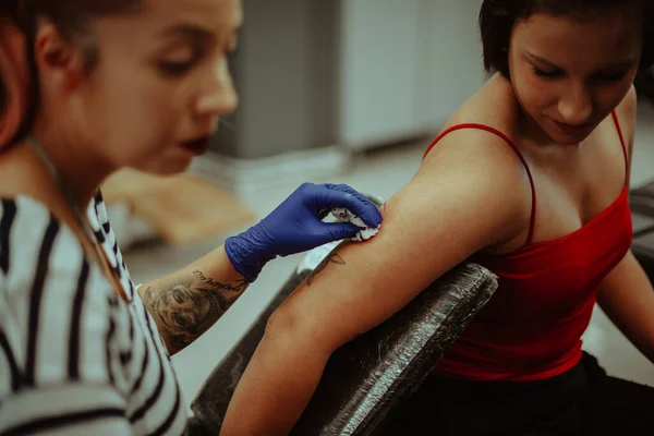 Blisko Tatuażystki Czyszczącej Tatuaż Swojego Klienta — Zdjęcie stockowe