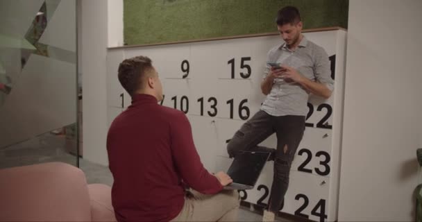Два Коллеги Разговаривают Показывают Интересное Своих Телефонах Офисе — стоковое видео