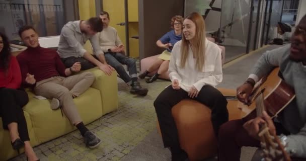 Молодые Коллеги Развлекают Коллегу Офисе Играя Гитаре Поя Вместе Пока — стоковое видео