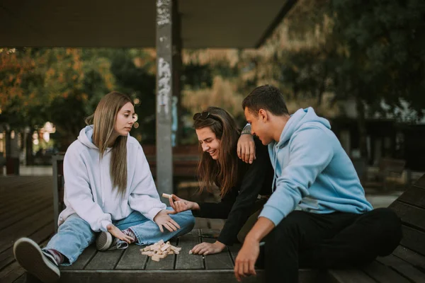 Drei Freunde Unterhalten Sich Auf Der Holzbank Über Das Verstreute — Stockfoto