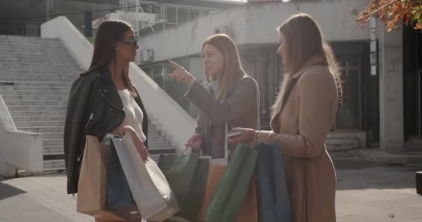 三个女孩打算在一个阳光灿烂的日子到购物中心外面去买东西 — 图库视频影像