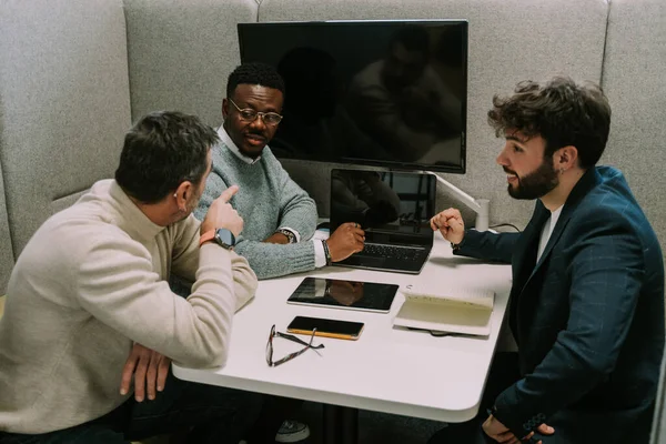 中年男性は黒人男性の同僚と話をする 彼は指摘している 腕の組立て — ストック写真