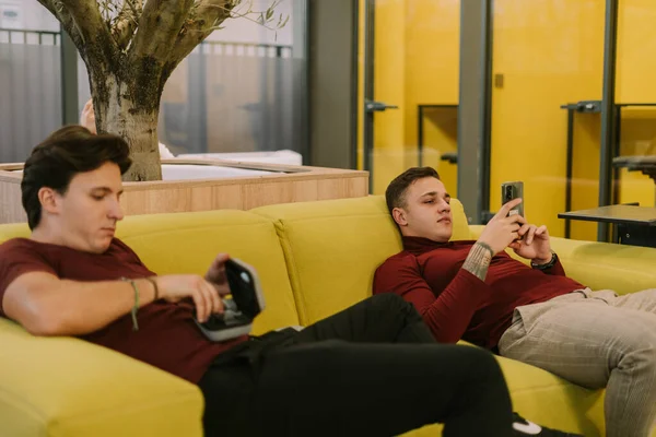 Gut Aussehende Männliche Kollegen Liegen Auf Einem Gelben Sofa Modernen — Stockfoto