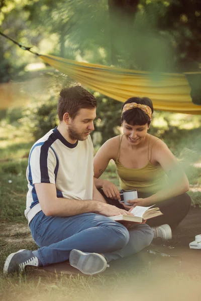在公园野餐的时候 这对年轻夫妇一起放松 一起看书 — 图库照片