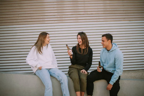Τρεις Χαρούμενοι Φίλοι Χαμογελούν Και Κάθονται Δίπλα Ένα Γκαράζ Κρατώντας — Φωτογραφία Αρχείου