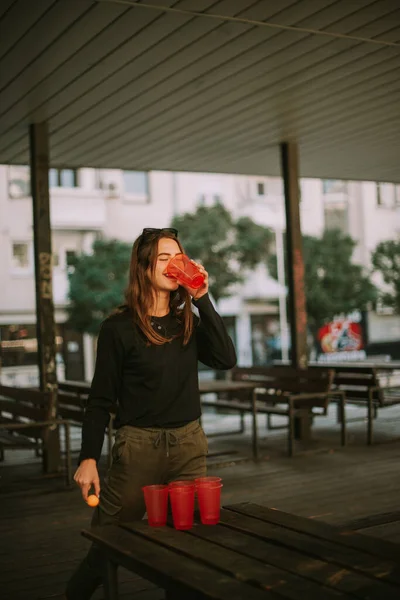 Krásná Dívka Pije Pivo Zatímco Hraje Pivní Pong Dřevěném Stole — Stock fotografie