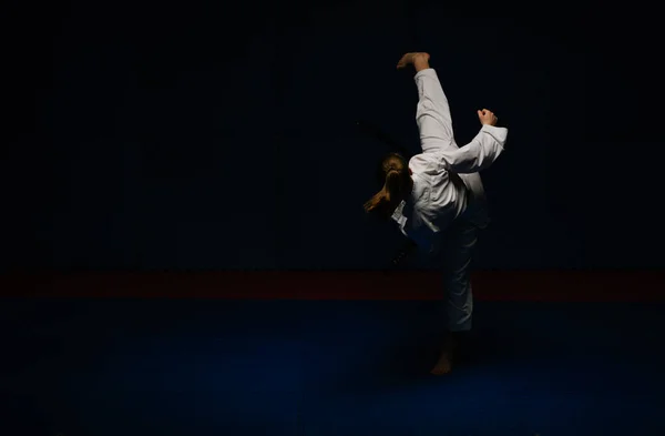 空手の練習をしている空手の女の子のシルエット空手のスタジオで後ろからMawashi Geri練習 — ストック写真