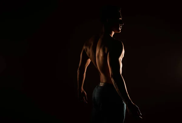 Silhouette of handsome man\'s back standing in the studio