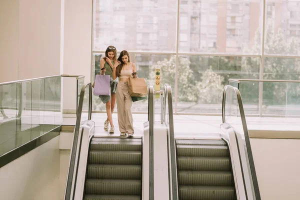 Dos Chicas Guapas Con Bolsas Compras Bajando Escalera Mecánica Del — Foto de Stock
