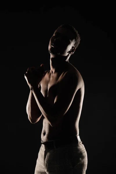 Perfect silhouette of black male posing topless