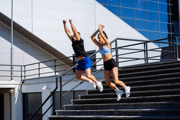 スポーツセンターの前の階段を飛び降りるハンサムな男と豪華な女性 — ストック写真