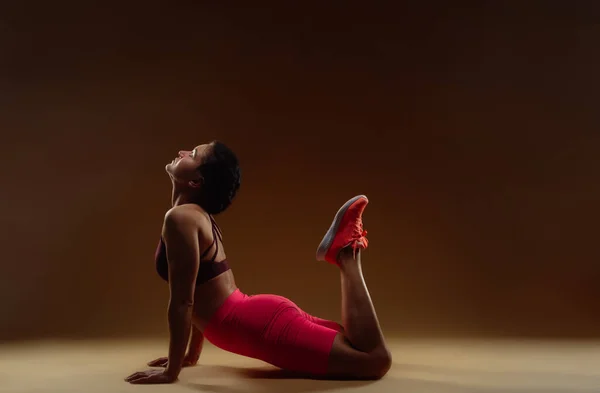 Stüdyoda Bej Arka Planda Çalışmadan Önce Kaslı Bayan Sporcu Vücudunu — Stok fotoğraf