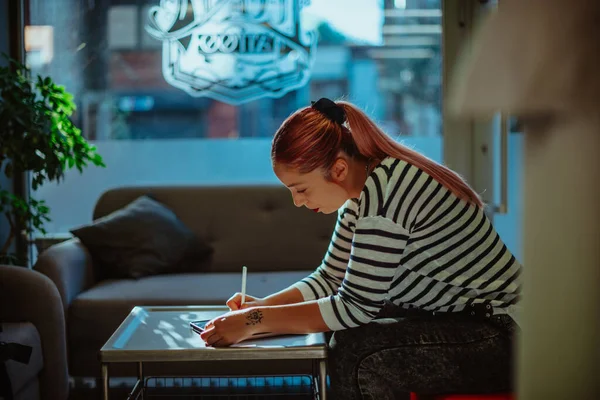 Güzel Kızıl Saçlı Dövme Sanatçısı Stüdyoda Otururken Çizim Yapıyor — Stok fotoğraf
