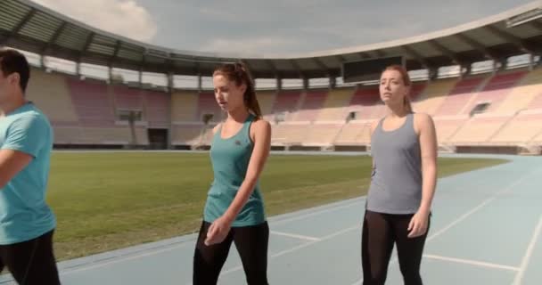 Three People Walking Race Track Stadium — Stock Video