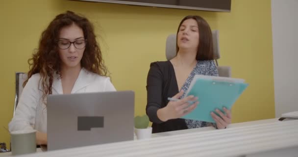 重要なプロジェクトで一緒にオフィスで働いている2人の女性マネージャー 現代のオフィススペース カメラトラック運動 — ストック動画