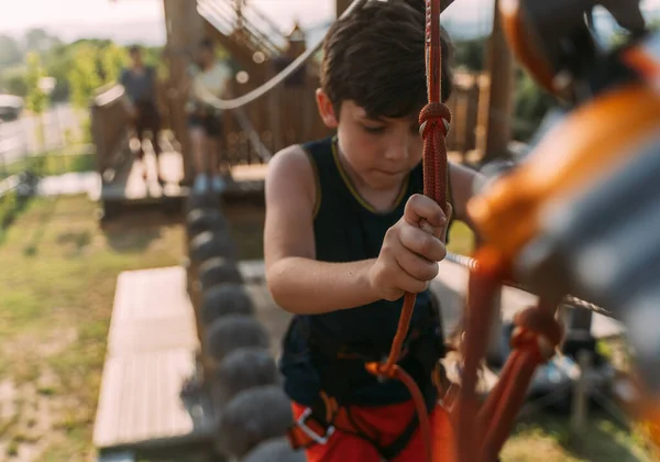 在冒险公园的木制圆圈上走着的小男孩的近照 — 图库照片