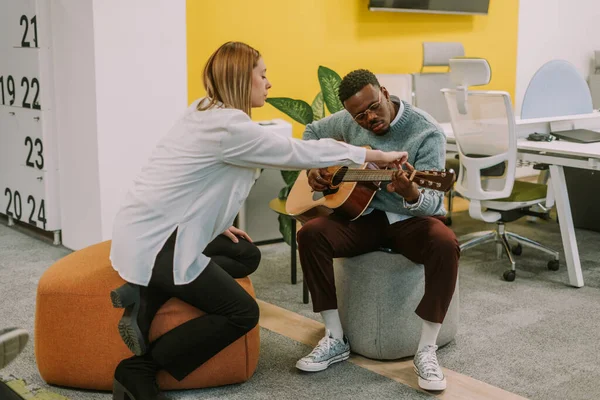 Sarışın Bir Kadını Zenci Arkadaşına Gitarda Nasıl Çalacağını Öğretiyor — Stok fotoğraf