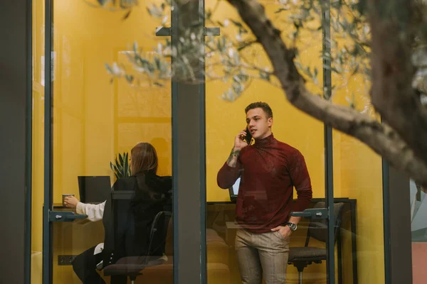 Yerindeki Küçük Sarı Odada Dikilirken Telefonda Konuşan Yakışıklı Bir Adamı — Stok fotoğraf