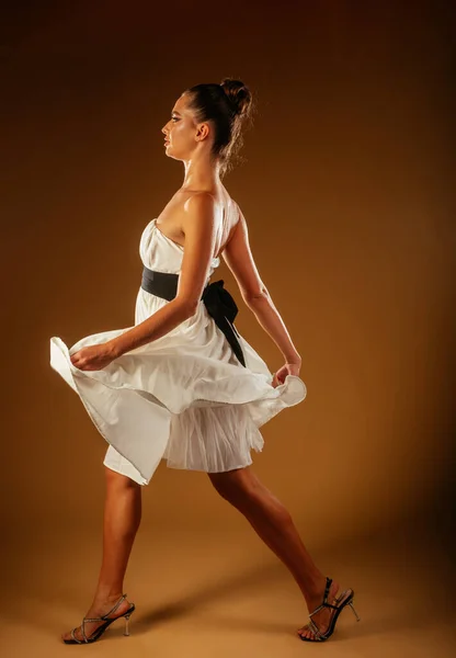 Ένα Ελκυστικό Κορίτσι Που Περπατάει Στο Στούντιο Λευκό Φόρεμα Και — Φωτογραφία Αρχείου