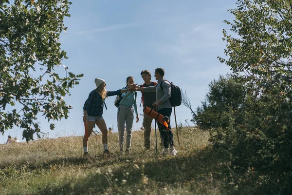 四个朋友 即徒步旅行者之间有误会 在他们继续登山之前 他们正在做交易 — 图库照片